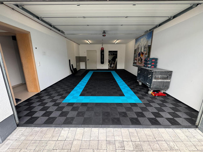 Private Garage mit schwarzem Garagenboden mit hellblauer Umrandung